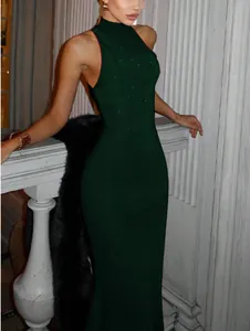 Detail of elegant dark green sequined evening gown with high neckline and sleeveless cut