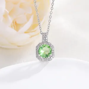 Macro shot of a square perfume bottle pendant with green zircon and silver chain