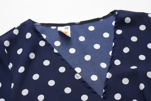 Detail of the V-neckline and fabric texture of the navy blue polka dot dress in size M