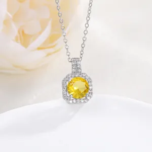Detail of silver necklace with yellow round-cut zircon and halo pendant setting