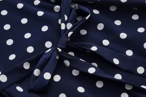 Detail of navy blue polka dot dress showing high-quality bow tie knot and chiffon texture