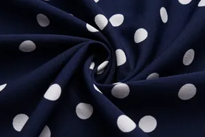 Macro view of navy blue chiffon fabric with white polka dots and fine texture