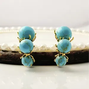 Vintage style gold earrings with three graduated turquoise stones and zircon accents