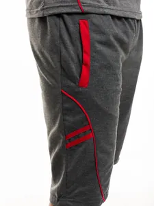 Detailansicht grauer Herren-Sportshorts mit auffälligen roten Paspeln und praktischer Tasche