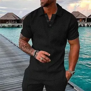 Close-up detail of men's black 3D textured polo shirt set with luxury resort background.