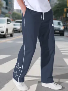 Full view of navy blue high street joggers with white side stripes and star embroidery