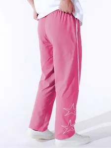 Close-up view of pink men's high street leisure trousers with white star embroidery