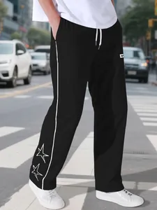 Detailed view of men's black sweatpants with white side stripes and star embroidery