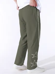 Back view of men's olive green joggers featuring white side stripes and star embroidery.