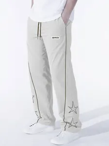 Macro view of men's gray high street sports trousers with star embroidery and brown stripes