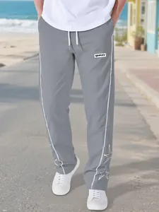 Detailed view of men's grey high street sports pants featuring white star embroidery details
