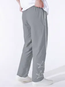 Rear view of grey sports pants with white star embroidery and side stripe