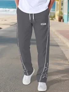 Close-up detail of gray high street men's pants with white star embroidery and side stripes