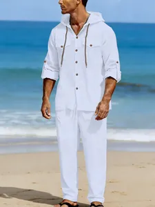 Man wearing a white linen long-sleeve hooded shirt and matching casual pants on a sunny beach