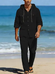 Detailed view of men's black linen hooded casual set on a sunny beach background