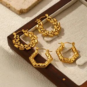 Gold stainless steel hoop earrings with hammered and linked textures in a display tray