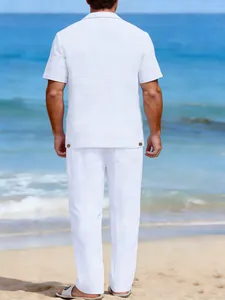 Vue arrière d'un ensemble chemise à manches courtes et pantalon en lin blanc sur plage
