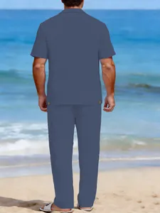 Vue arrière d'un ensemble en lin bleu pour homme avec chemise et pantalon sur la plage