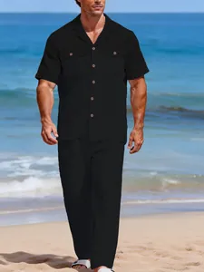 Détail d'un ensemble décontracté en lin noir pour homme porté sur une plage ensoleillée.