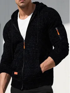 Close-up of black textured jacquard hooded sweatshirt with orange zipper detail.