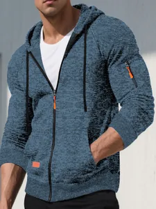 Close-up of men's blue jacquard sports hooded jacket featuring vibrant orange zipper pulls