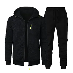 Detailed view of men's black hooded sweatshirt and jogger pants tracksuit fitness set.