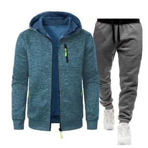 Two-piece men's athletic set with a blue jacquard zip-up hoodie and grey jogger pants.
