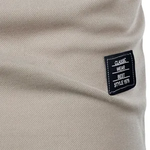 Close-up of beige breathable fabric texture and classic wear patch on men's shirt