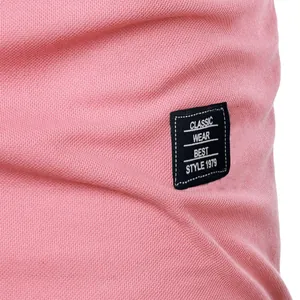 Close-up detail of pink men's pique polo shirt featuring a black classic wear patch