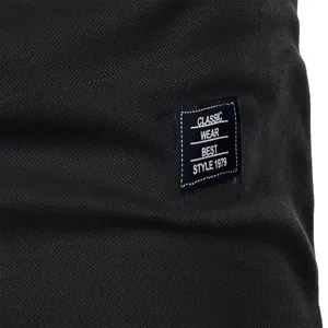 Macro view of black men's shirt detail featuring a Classic Wear woven label.