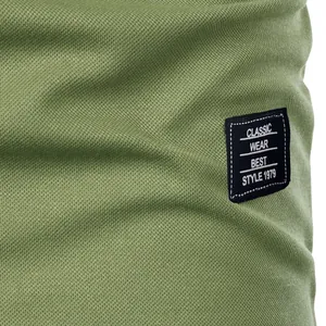 Macro view of olive green pique fabric texture with stitched 'Classic' text patch