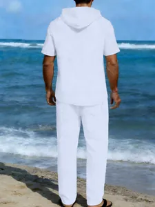 Vista posteriore di un uomo con camicia con cappuccio e pantaloni in lino bianco