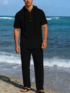 Dettaglio del set da uomo in lino nero con camicia con cappuccio e pantaloni casual.
