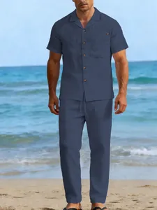 Men's navy blue linen short sleeve shirt and long pants set shown on a sunny beach