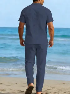 Back view of men's blue linen short sleeve shirt and long pants set on a sunny beach