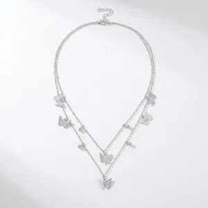 Detail view of silver double-layered necklace with elegant butterfly charms and beads