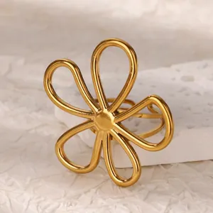 Macro detail of a minimalist gold hollow five-petal daisy ring in durable titanium steel