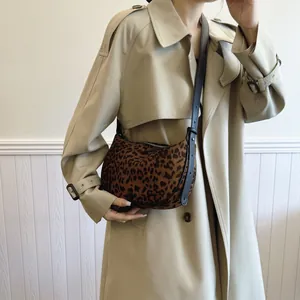 Leopard print suede crossbody bag styled with a classic beige trench coat