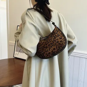 Fashionable leopard print matte underarm hobo bag styled with a stylish beige trench coat