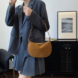 Brown suede hobo bag styled with a grey blazer for a chic modern minimalist outfit look.