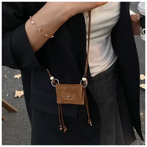 A detailed view of this retro brown suede mini crossbody bag showcasing its soft texture.