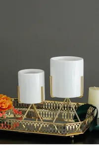 Detailed view of minimalist white ceramic flower pot with gold-plated iron tripod stand