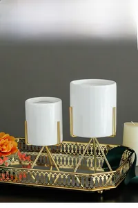 Detailed view of minimalist white ceramic flower pot with gold-plated iron tripod stand