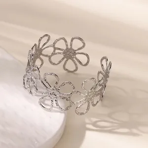 Detailed macro shot of a silver hollow daisy flower cuff bracelet with a textured metal finish.