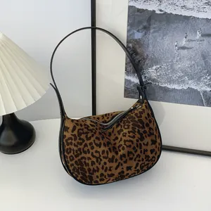Detailed view of a fashionable leopard print suede baguette bag in a minimalist lifestyle setting