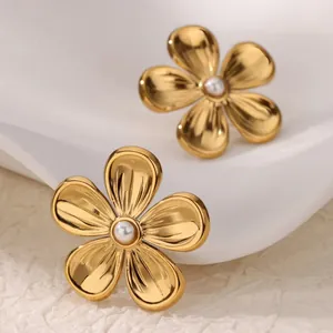 Detailed view of elegant golden five-petal flower earrings with a small white pearl center