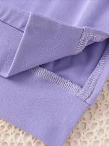 Close-up of purple girls' sweatshirt side slit hem with reinforced stitching