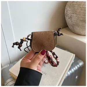 Detailed macro view of vintage brown suede mini coin purse with wood beaded decoration