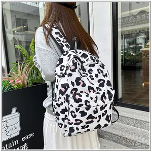 Fashionable leopard print lightweight school backpack shown being worn in a stylish outdoor setting