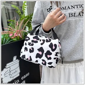 Close-up view of a leopard print lunch bag with black handles and pink accents